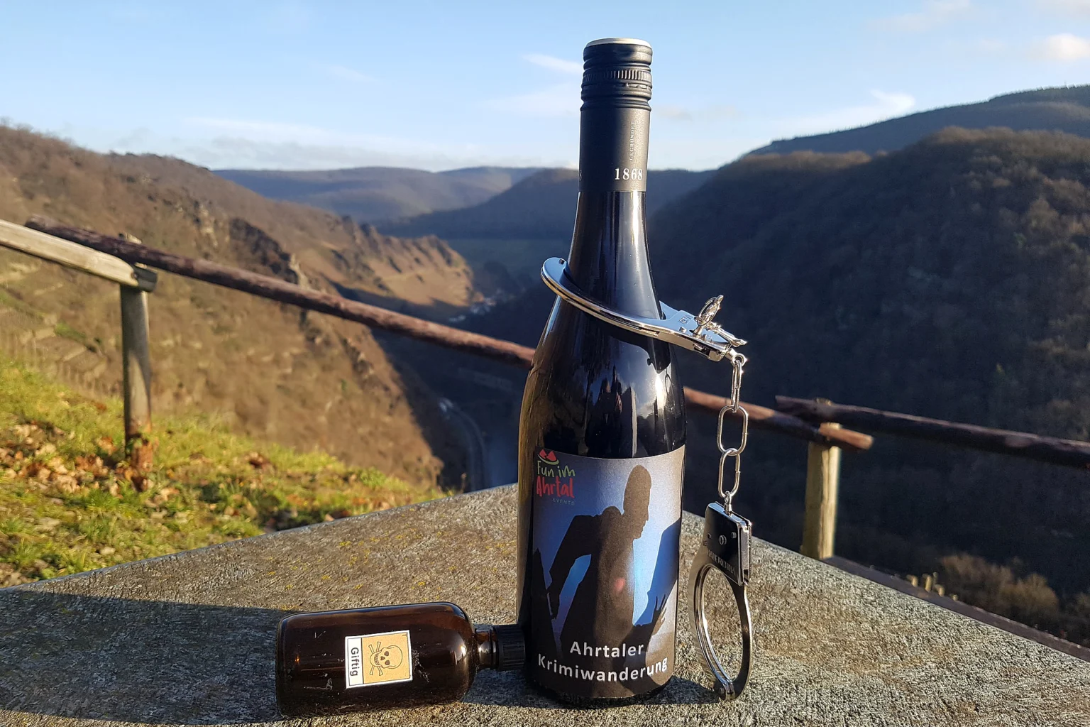 Flasche Ahrwein mit der Aufschrift „Krimiwanderung“ vor Ahrtalbergen.