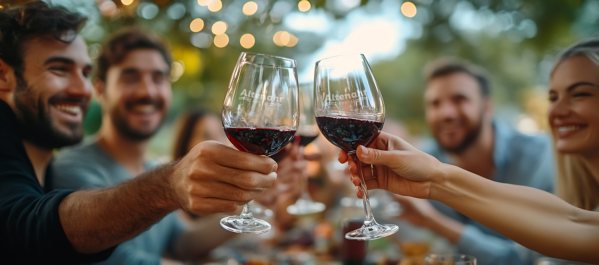 Fröhliche Menschen prosten sich mit einem Glas Rotwein zu.